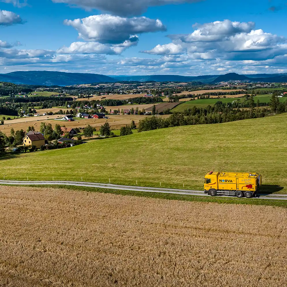 Landbrukslandskap sett fra luften med traktor i arbeid